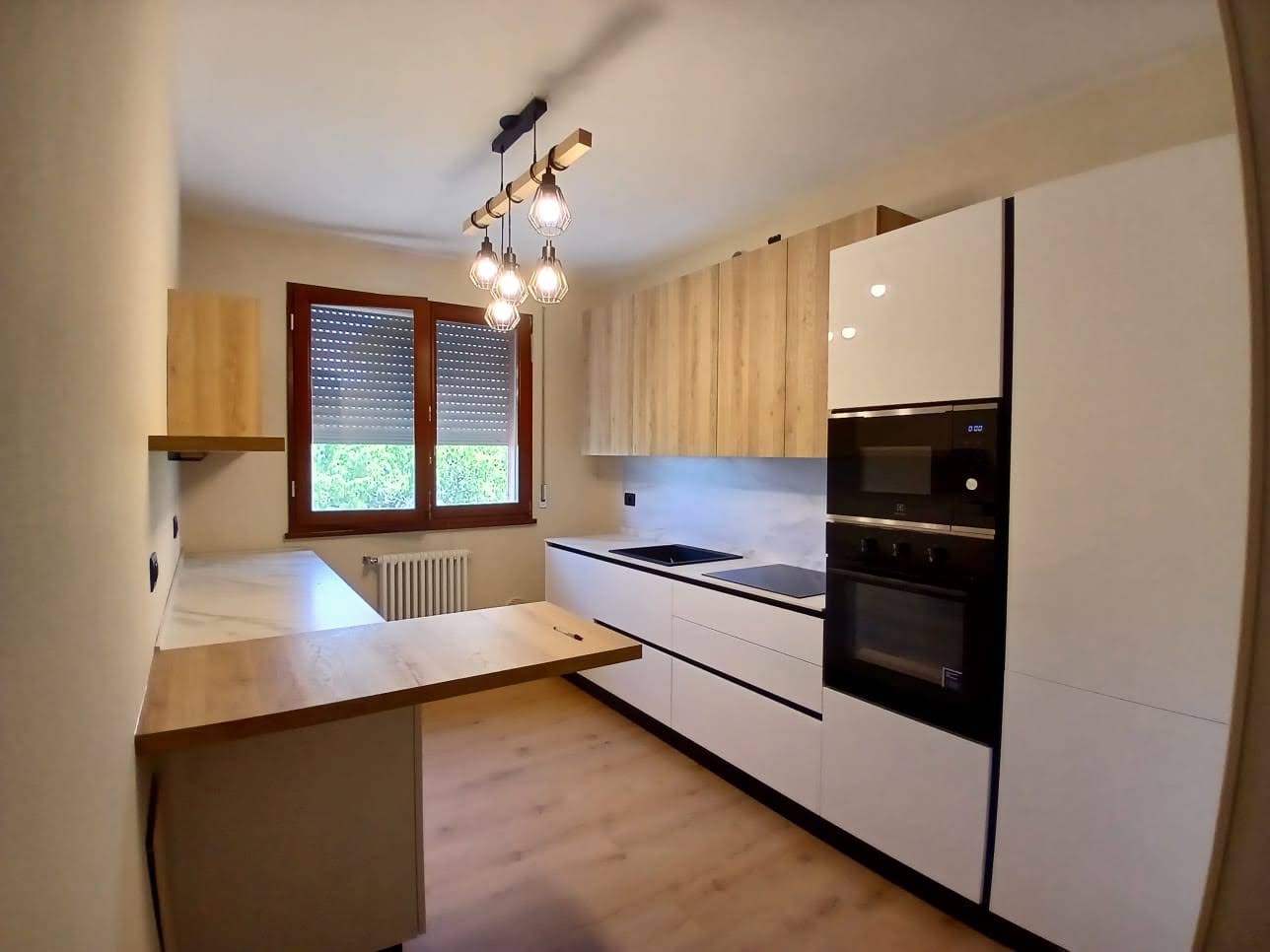 Cucina chiara con pavimento effetto legno dopo il rinnovo