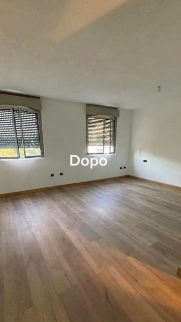 Stanza rifinita con pareti chiare e pavimento effetto legno